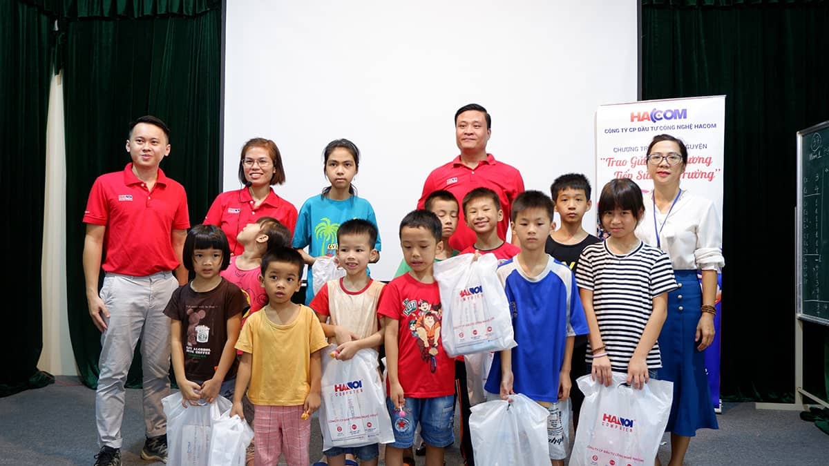 Nhân viên HACOM trao quà tặng tình thương cho các em học sinh